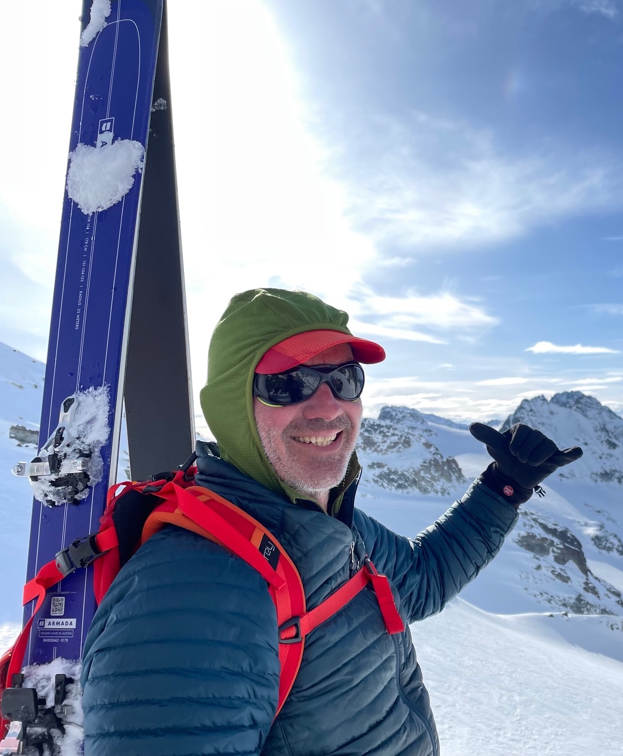 Dave in the Swiss Alps with skis and pack on his back.