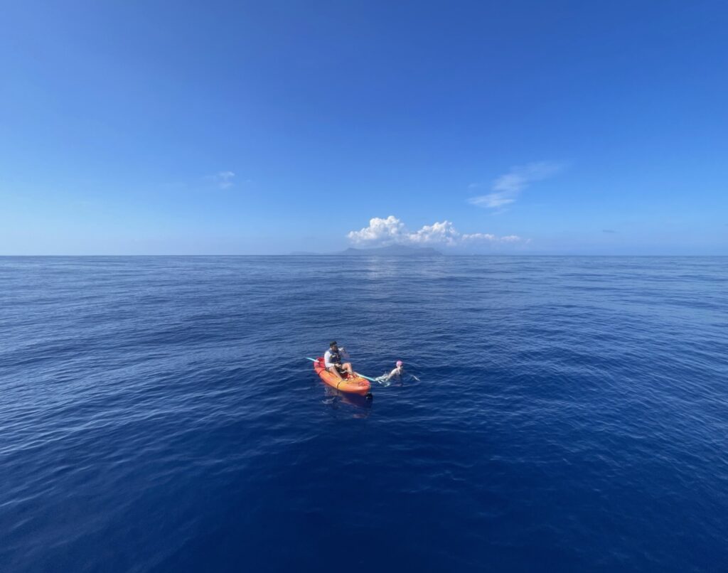 Maya swimming in the ocean with kayak support