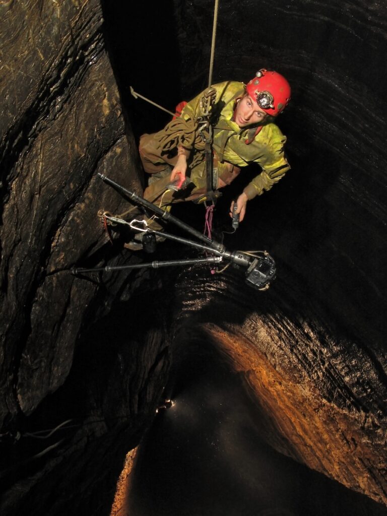 Robbie descending a deep cave shaft