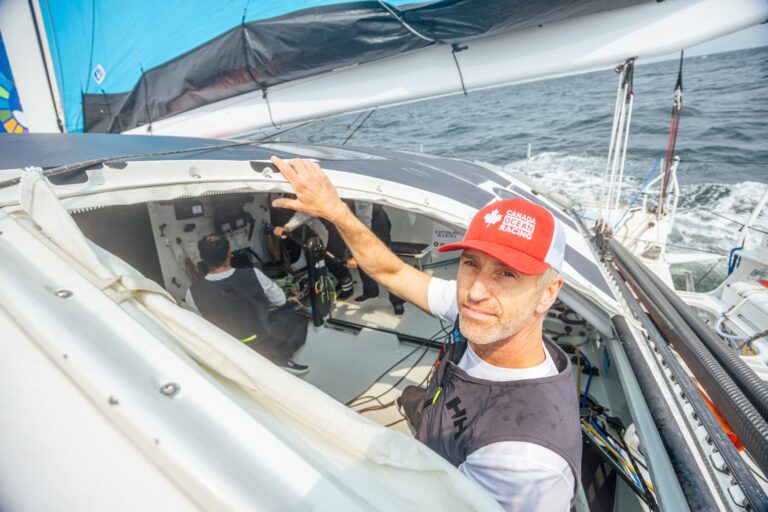Skipper looking out from the cockpit of Canada Ocean Racing's sailboat under sail