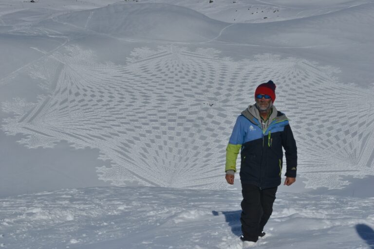 Simon posing above a completed snow drawing