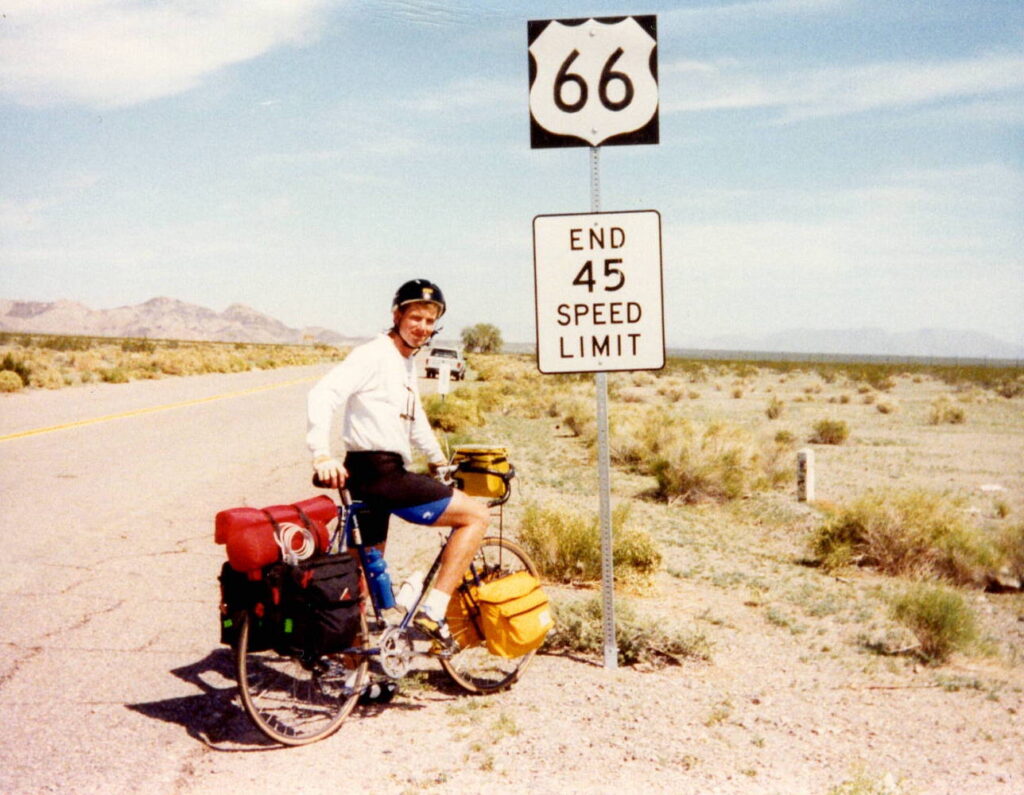 Cycling past a Route 66 sign on a desert highway