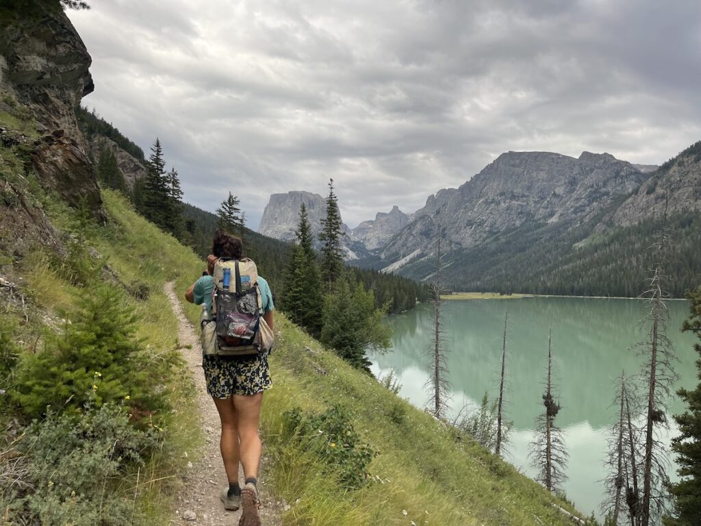 Grace hiking alongside a mountain lake