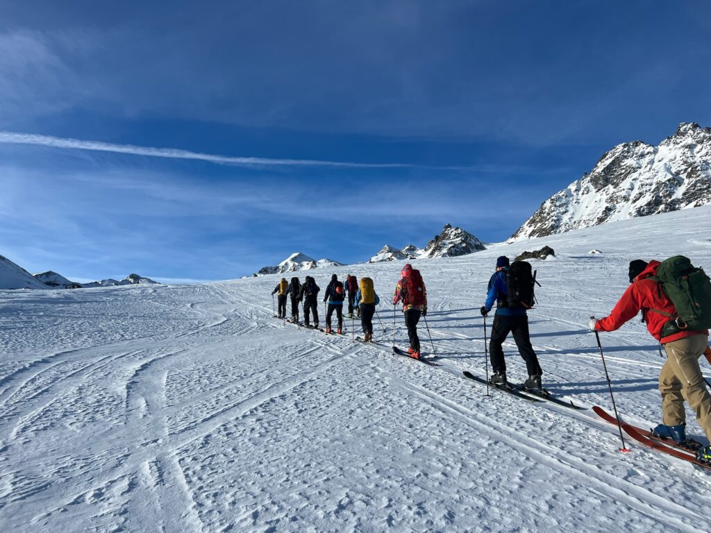 Skiers trudging up a mountainside