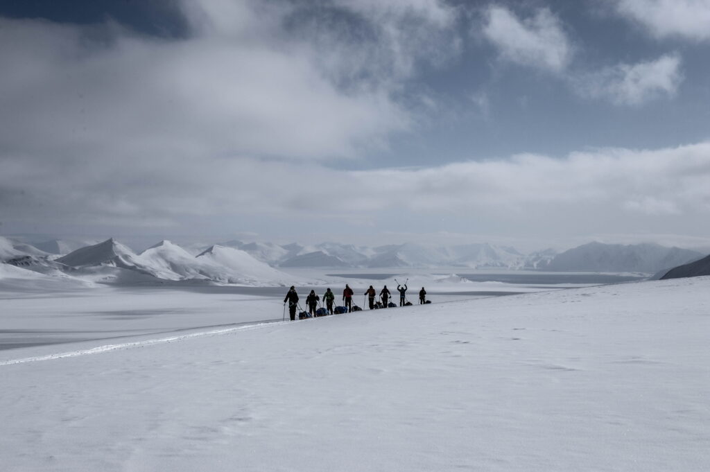 Skiers in a line during a day's travel across a frozen landscape