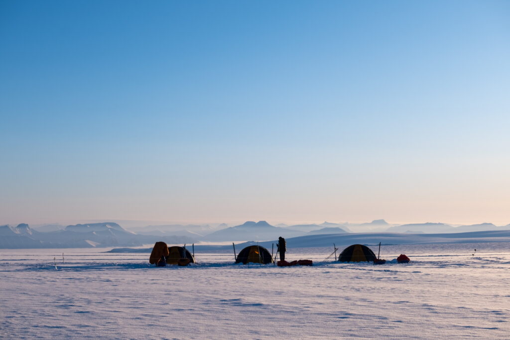 Tents set up in the frozen arctic wilderness.