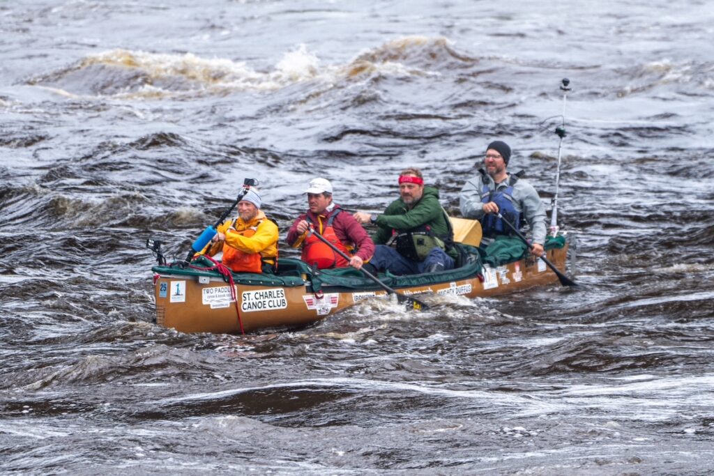 The canoe charging down rapids on the Mississippi River