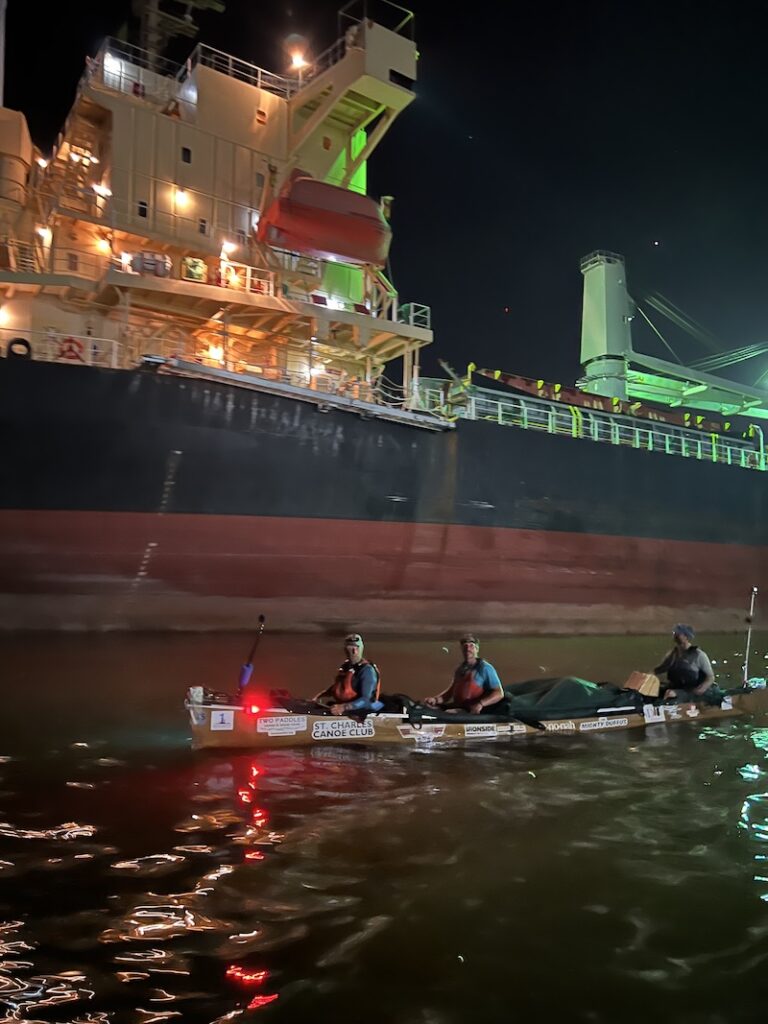 A night shot of the canoe passing a giant freighter