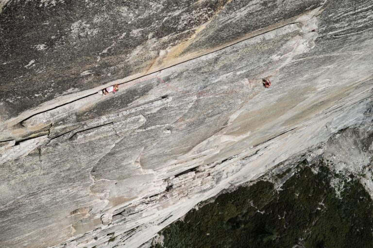 A climber on a precariously thin ledge high above Yosemite
