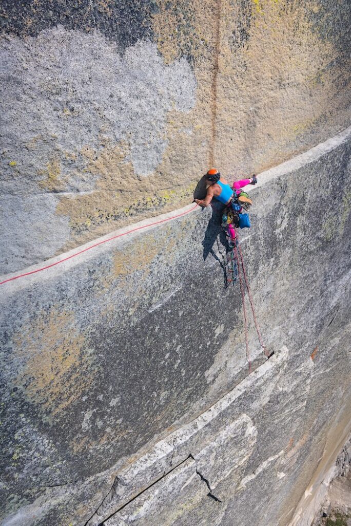 A climber on a precariously thin ledge high above Yosemite