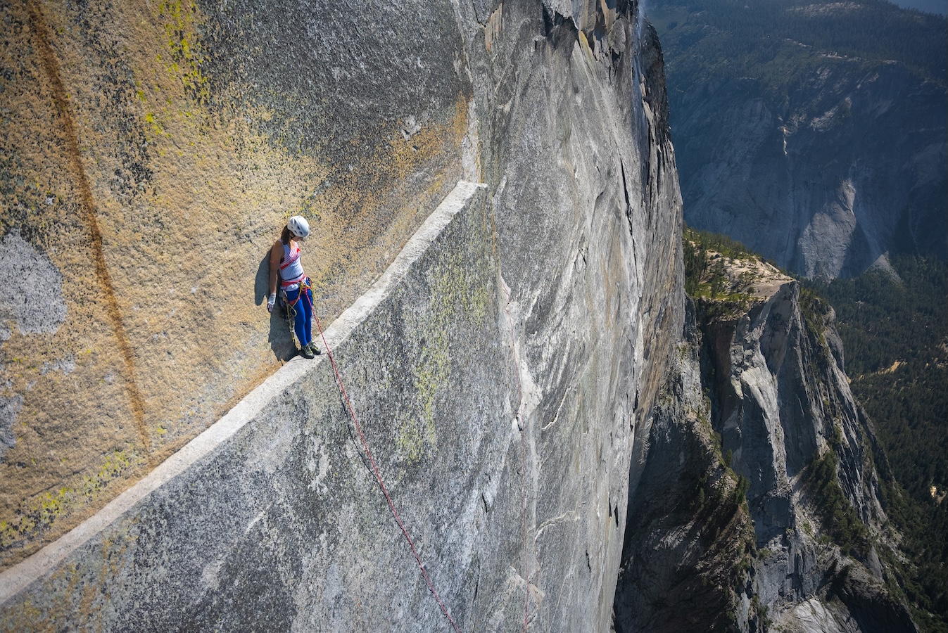 A climber on a precariously thin ledge high above Yosemite