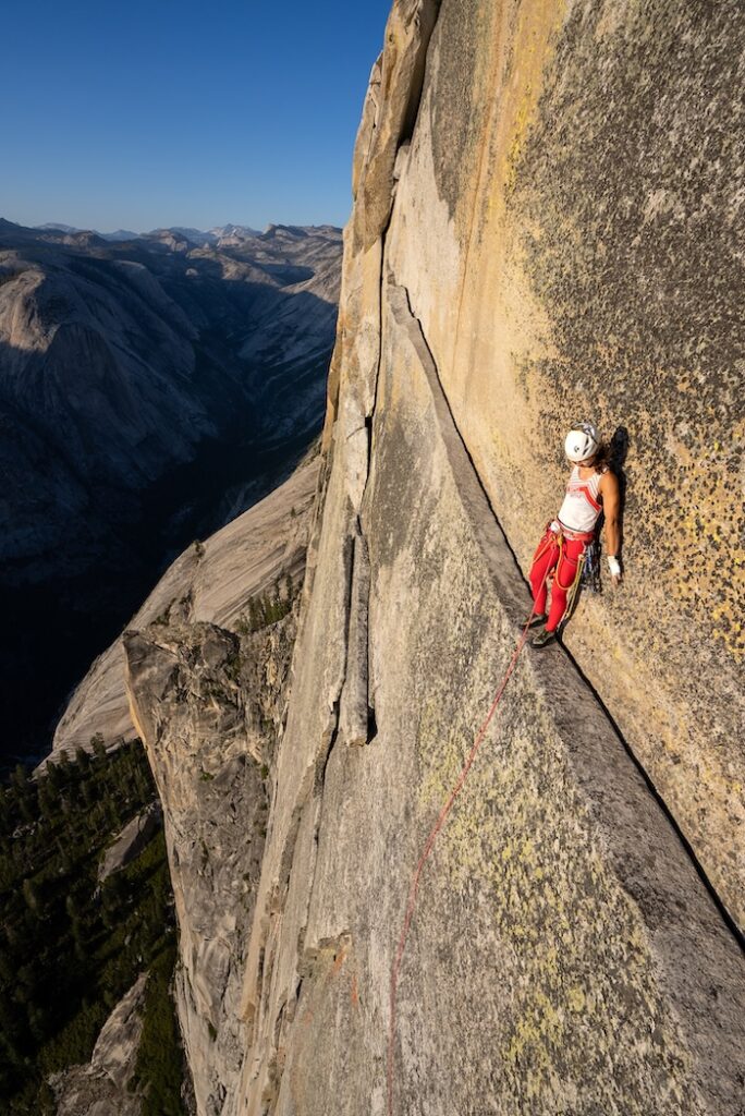 A climber on a precariously thin ledge high above Yosemite
