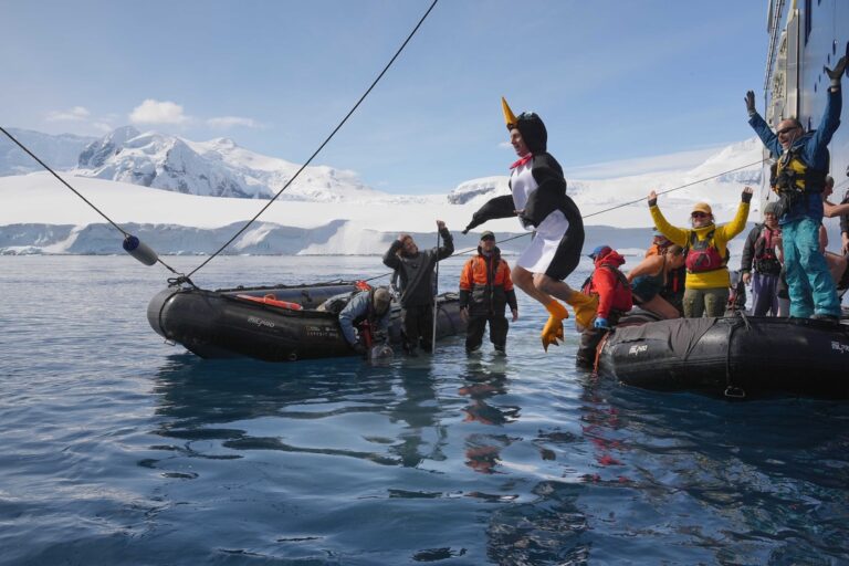 Me in a penguin costume doing a polar plunge in the Antarctic Ocean