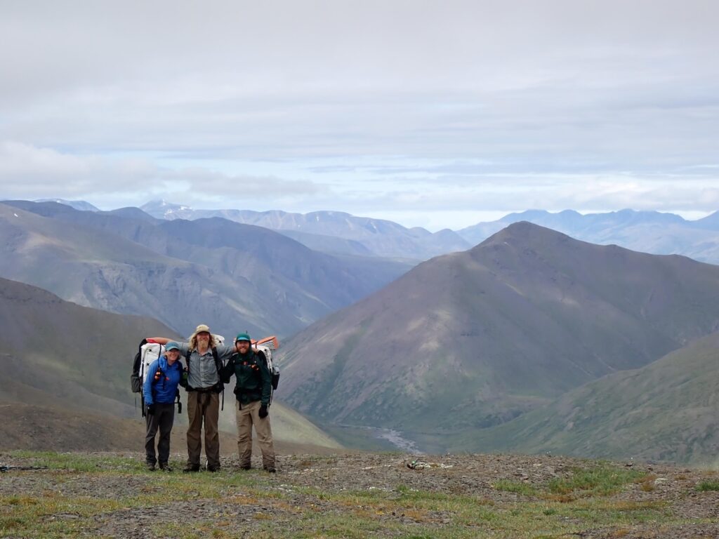 The group of backpackers with endless mountains behind them