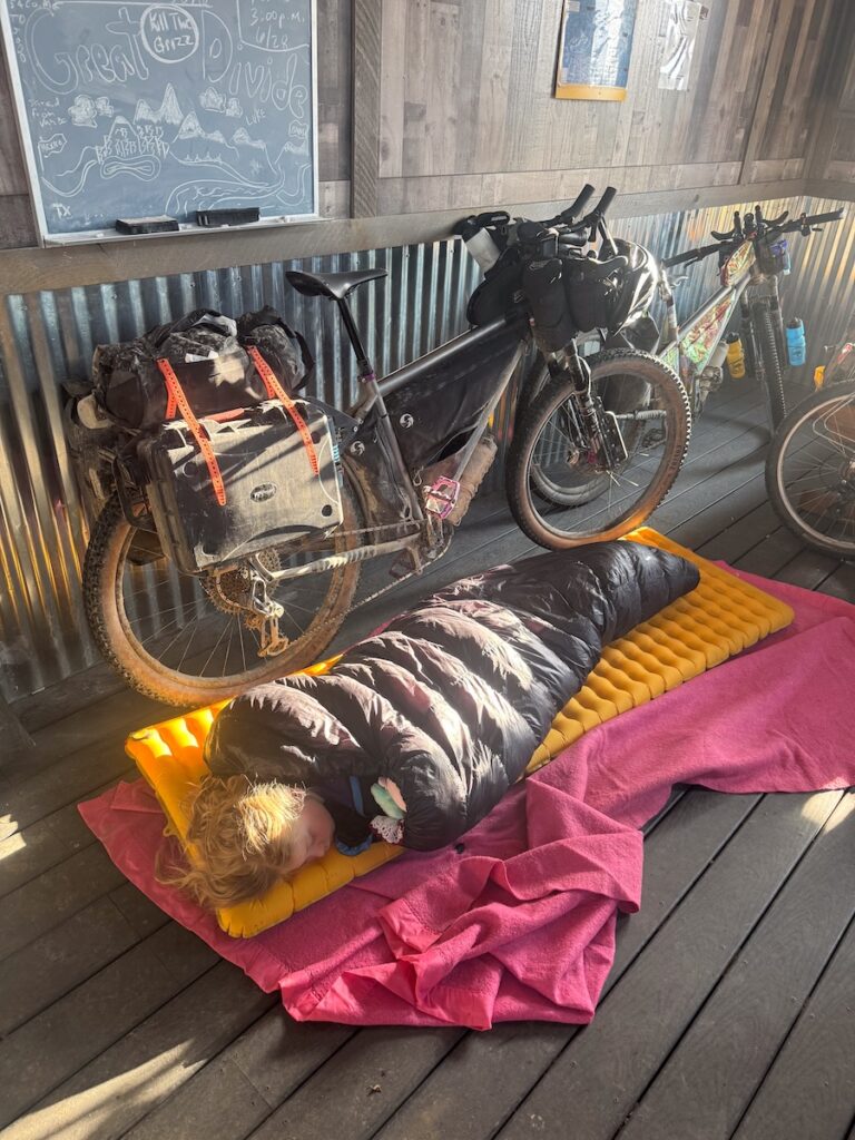Molly asleep on a porch with her bike