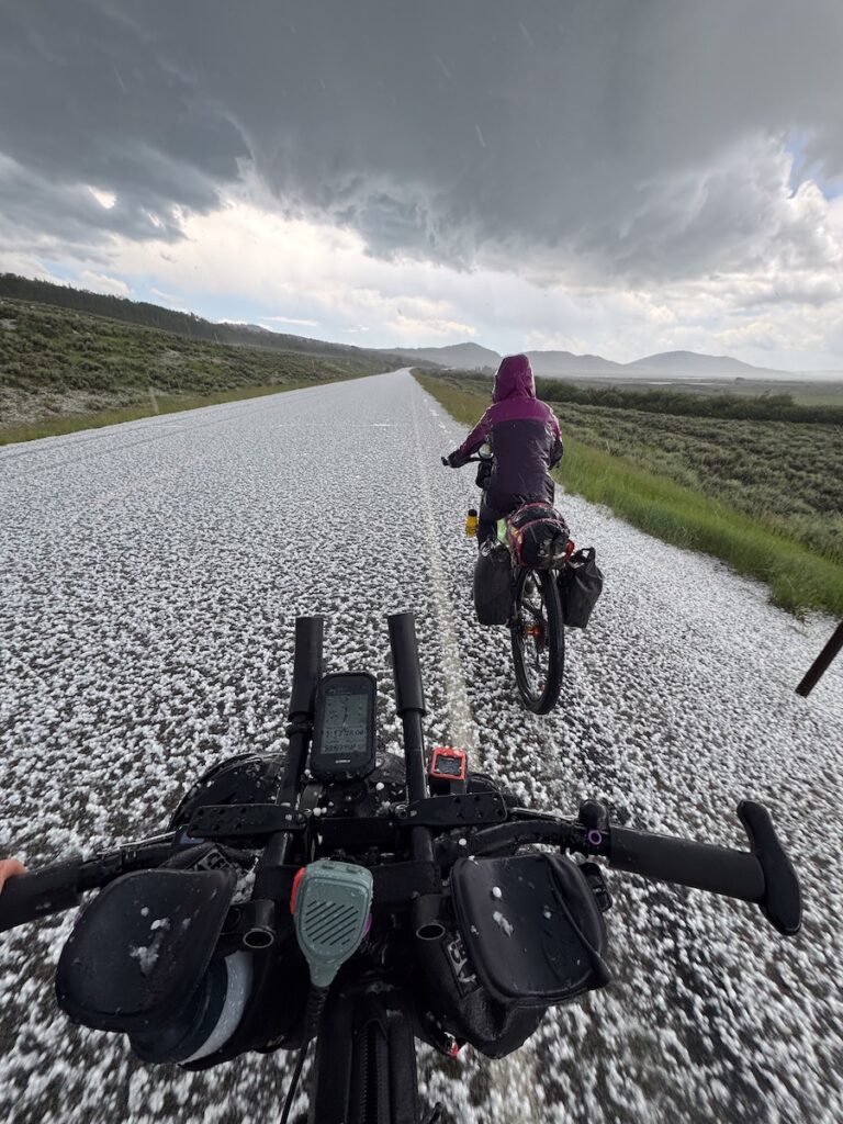 Molly riding her bike on a road covered in hail stones