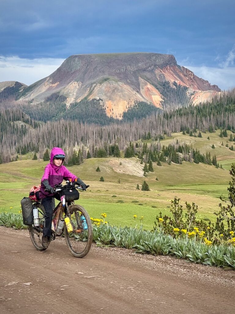 Molly riding with a large mesa in the background