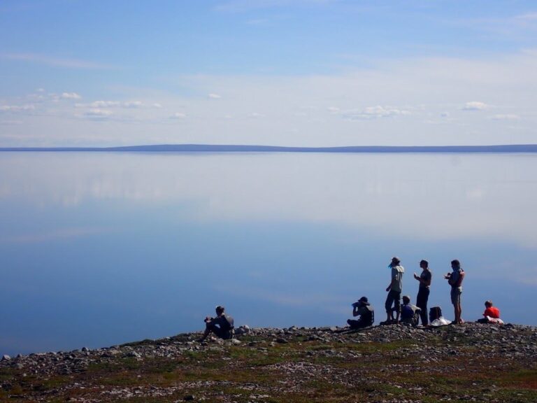 Paddlers on the shore of a glassy calm lake