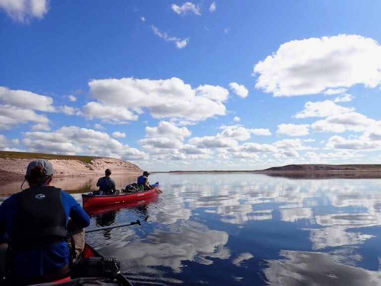 Mirror-like reflection of blue sky and clouds on the lake surface