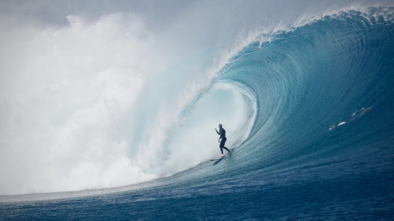 Surfer in the barrel of a big wave at Cloudbreak