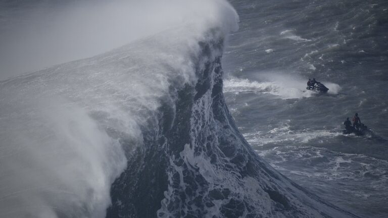 Building-sized wall of water above jet skiers at Nazare