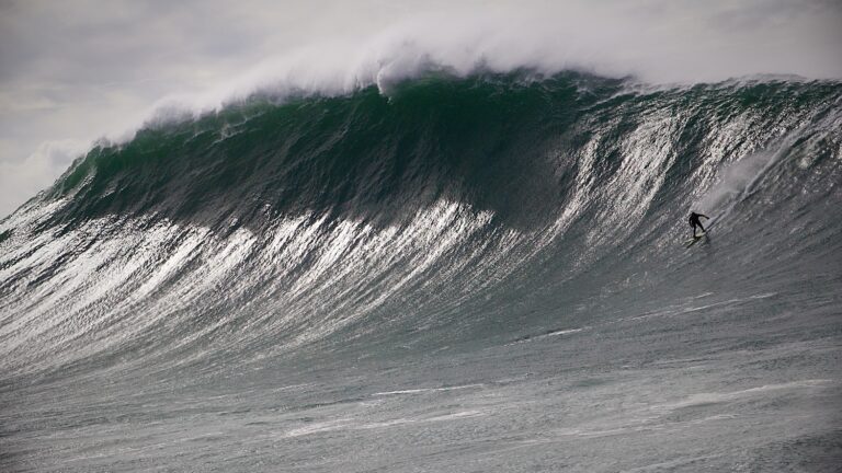Surfer riding a big wave at Nazare