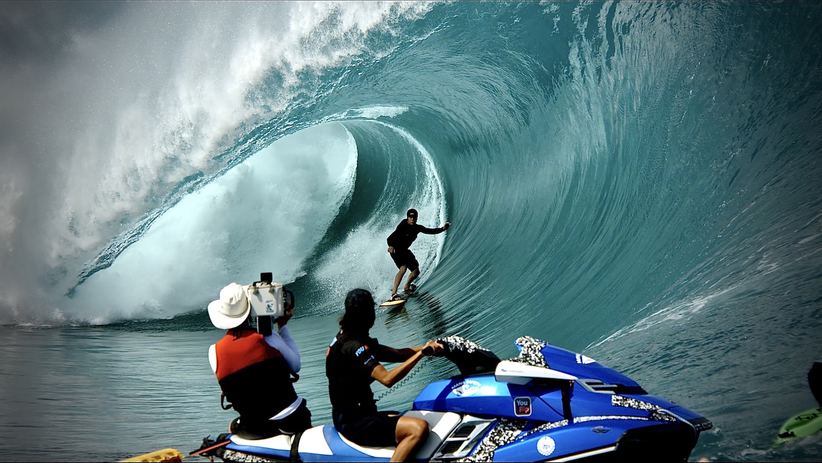 Tim on a jet ski filming a surfer barreling towards him
