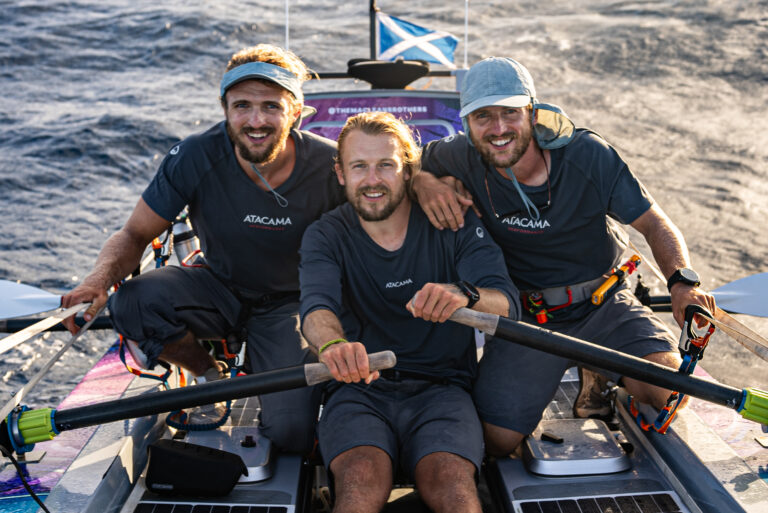 All 3 Maclean brothers posing in their rowboat